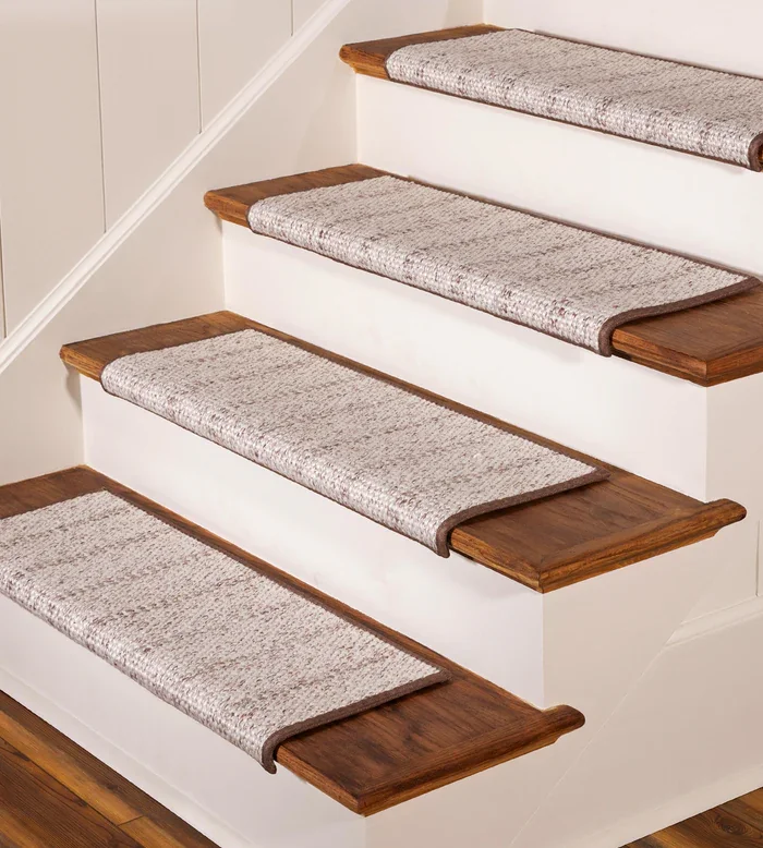 Each stair has a rectangular, light-colored synthetic carpet tread with a dark brown border.