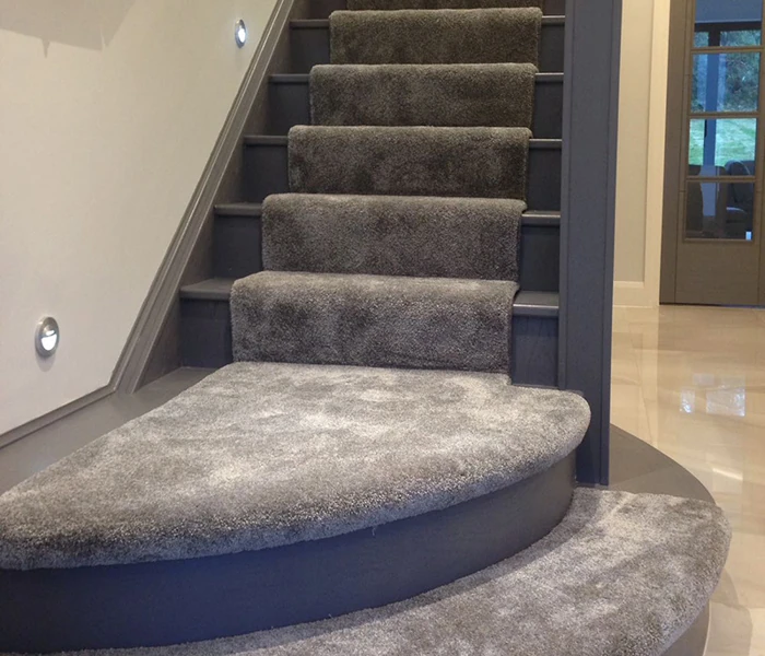 Silk stair carpet with soft grey finish on modern curved staircase