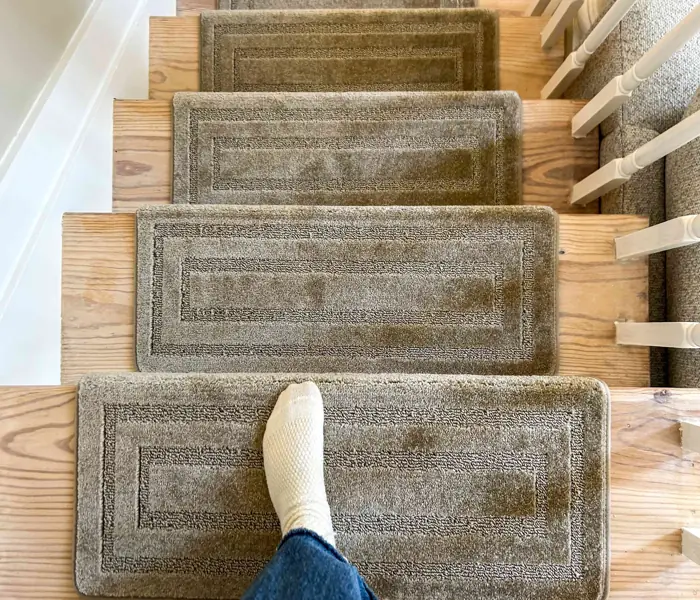 dark gray wool stair treads with a low-profile, textured weave installed on light-colored wooden stairs