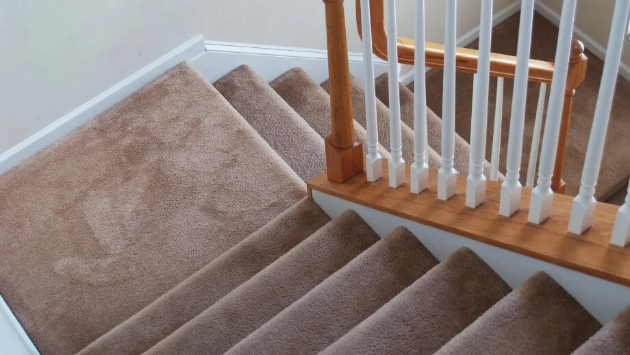 flat-weave sisal stair runner featuring a vertical orange and cream striped border.