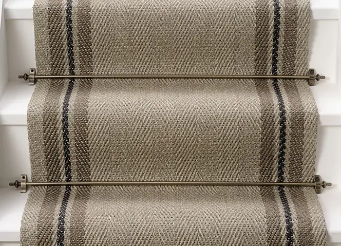 herringbone-weave sisal stair runner in a light oatmeal color, featuring a dark navy and charcoal striped border.