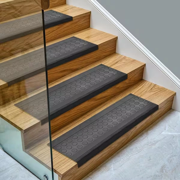 modern glass railings features four steps, each fitted with a rectangular charcoal gray nylon stair tread.