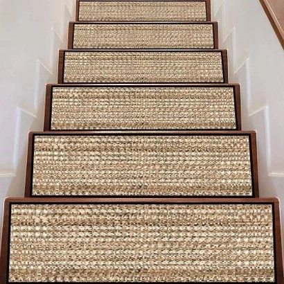natural jute stair treads with a woven texture and dark borders, installed on dark wood steps against white walls.