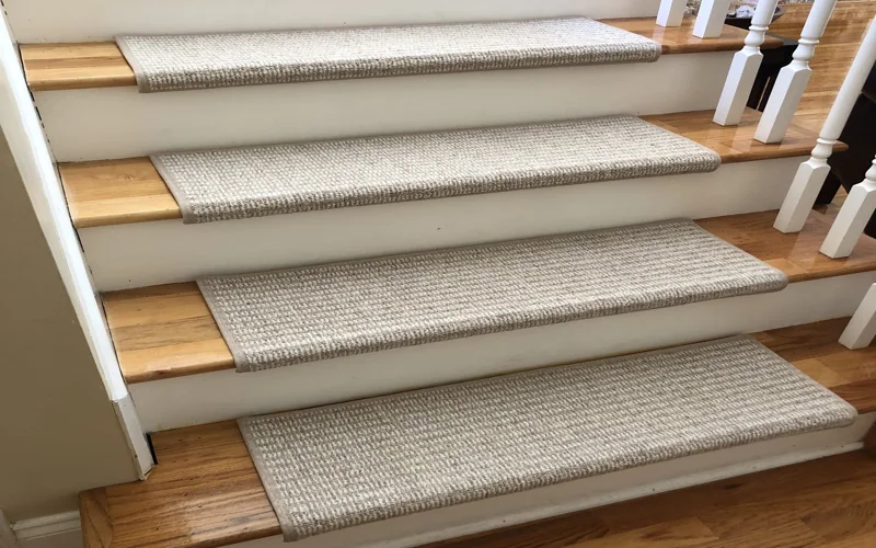 short-pile wool stair tread carpet with a finished bullnose edge, installed on a wooden step.