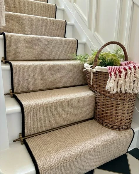 sisal stair runner carpet in a neutral beige tone with a contrasting black fabric border,