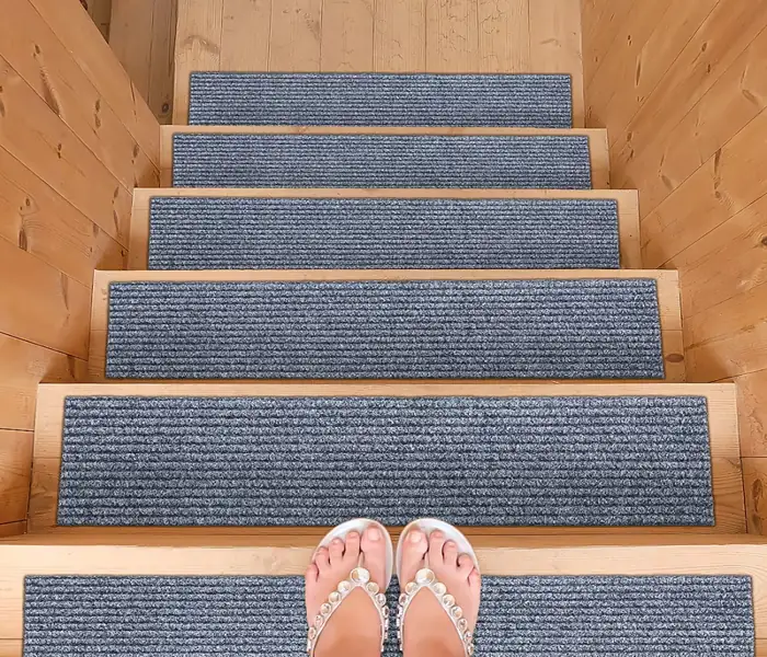wooden staircase featuring grey, ribbed anti-slip stair treads on each step.