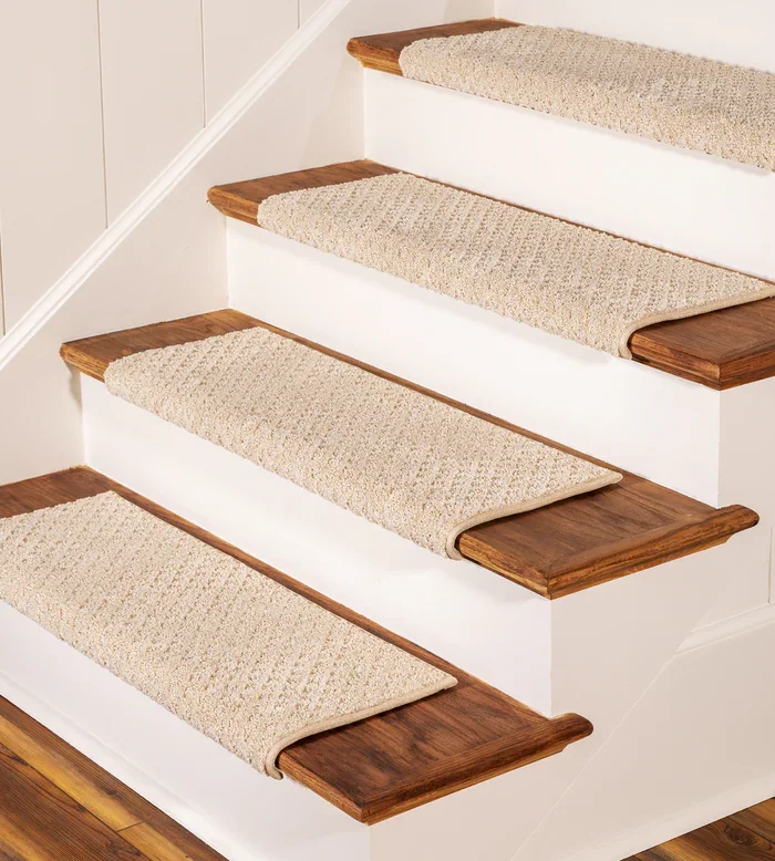 wooden stairs featuring cream-colored, textured synthetic carpet treads