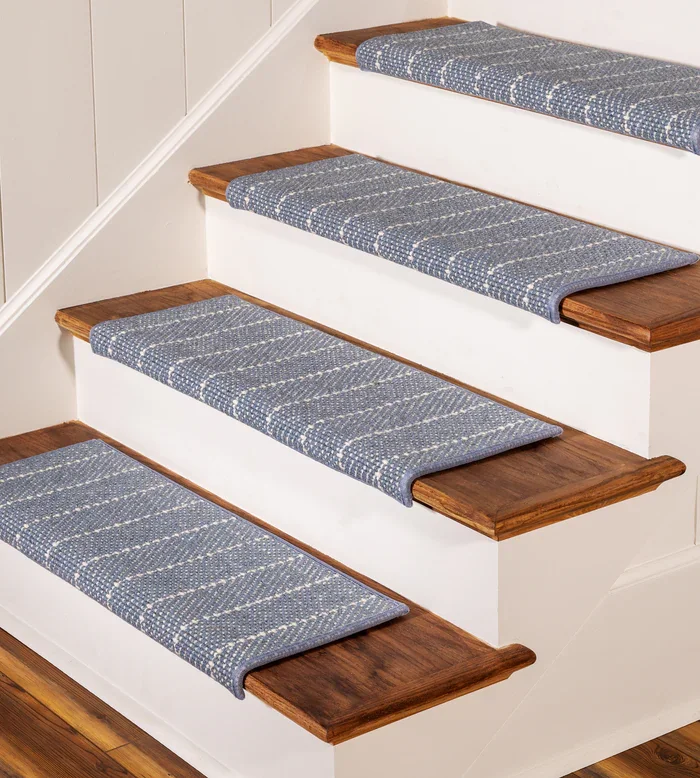 wooden stairs featuring individual blue and white patterned wool stair treads.