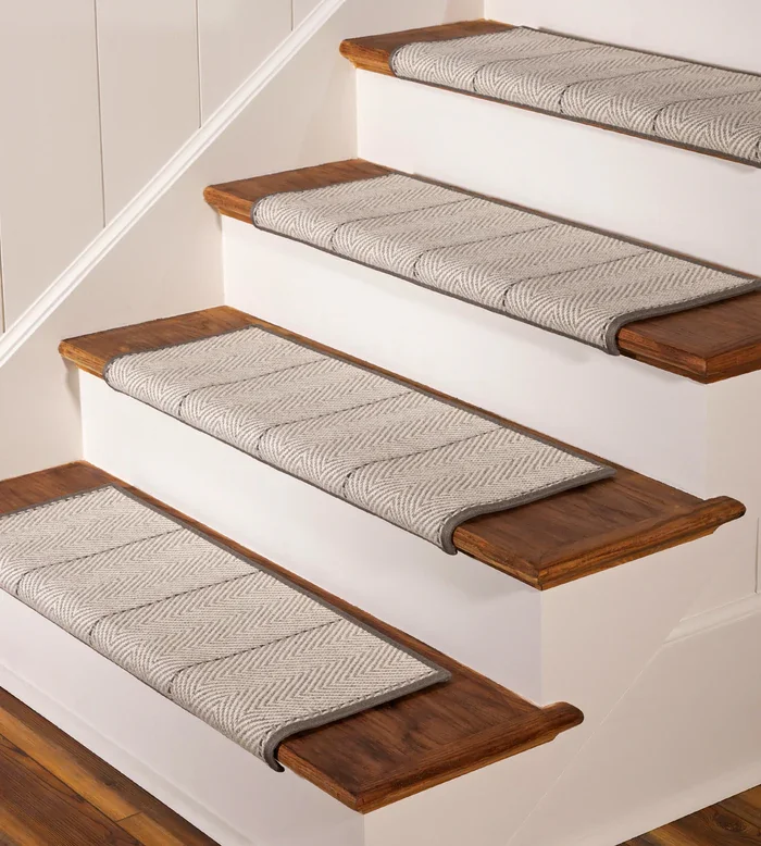 wool stair tread rugs with a textured [Pattern, e.g., Berber] weave on a wooden staircase.