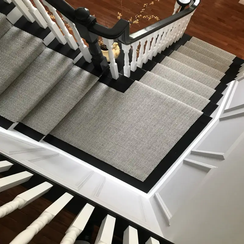 Black and White Chevron Stair Runner on a black wood staircase with white banisters.
