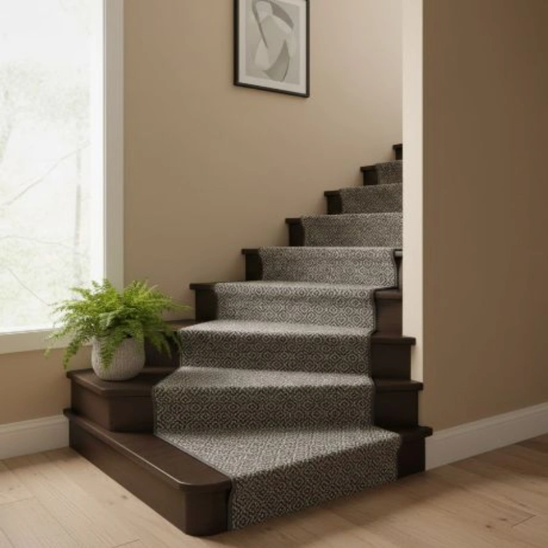 Dark gray geometric diamond patterned carpet runner installed on wooden stairs.