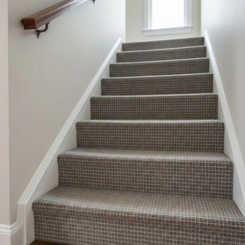 Detailed view of a brown and white plaid carpet runner on a single stair step.