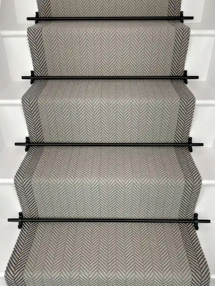 Grey chevron patterned bordered stair carpet runner with contrasting dark grey side borders and black stair rods for Bordered Stair Runners Dubai.