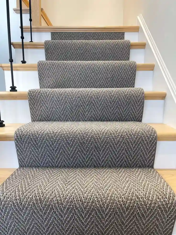 Grey textured herringbone nylon stair carpet runner installed on wooden steps for Nylon Stair Runners Dubai.