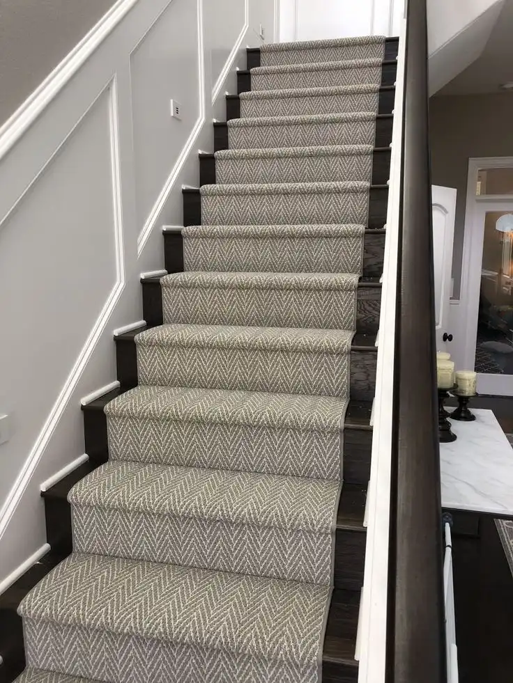 Grey textured patterned carpet runner seamlessly fitted on dark hardwood staircase for Custom Stair Runner Dubai.