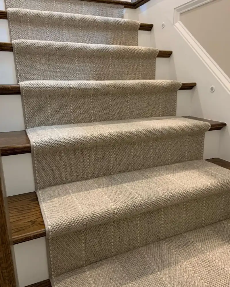 Natural-tone textured loop pile stair runner fitted seamlessly on wooden steps for Natural-Tone Stair Runners Dubai.