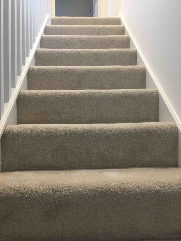 Neutral beige Hollywood style fitted stair carpet neatly tailored around each step for Stair Carpet Runners Dubai.